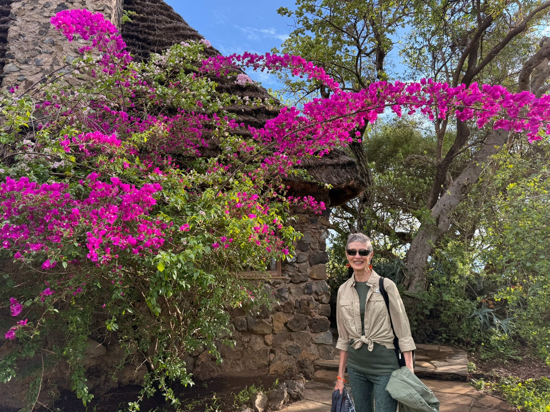 JP standing beside bright bougainvillea at Campi Ya Kanzi